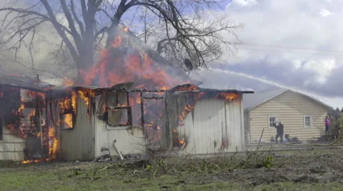 Firemen water a nearly destroyed house Stock Footage 61192453