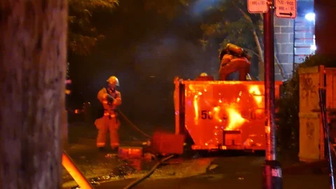 Firemen watering cardboard during garbage fire Stock Footage 116712191