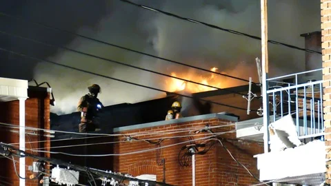 Firemen watering flames Stock Footage 115931859