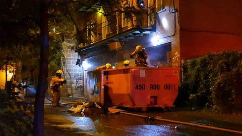 Firemen watering garbage fire Stockbeeldmateriaal 116712413