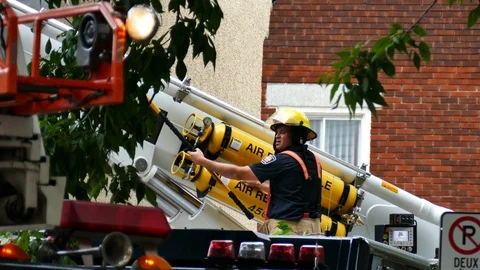 Firemen without bunker working on firetruck with instrument Stockbeeldmateriaal 116712824