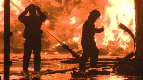 Firemen at work  fighting a huge blaze at an Industrial plant. Stock Footage 10686262