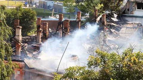 Firemen work on a very smoky object Stock Footage 80021416