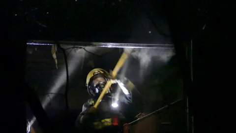 Firemen working with an ax at night Stock Footage 89523164