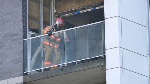 Firemen working on a balcony Stock Footage 99842186