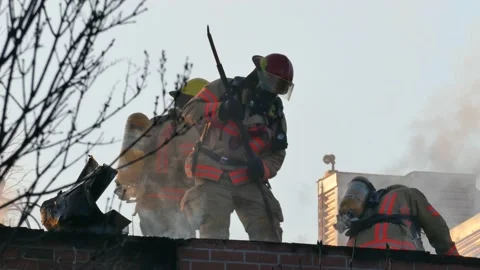 Firemen working hard at apartment fire with grey smoke Video stock 138530911
