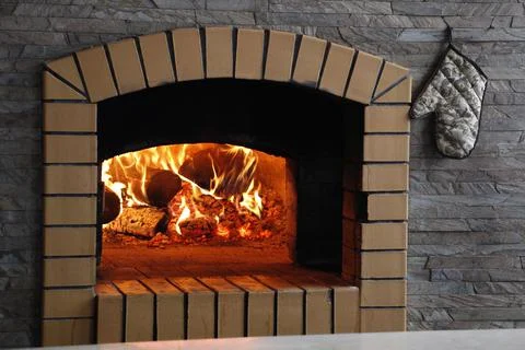 Fireplace with burning fire. Brick wall Stock Photos