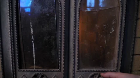 The fireplace doors are being opened, and the wood and fire are inside Stock Footage 95528171