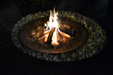 Fireplace with fire inside ancient external round bottom. Stock Photos