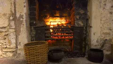 Fireplace in an old stone house with kitchen tools Video stock 85243002