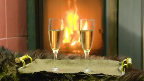 By the fireplace two glasses with champagne stand on a tray Stock Footage 130636370