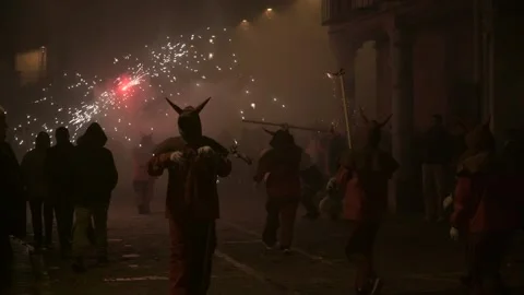 Firerunners with smoke, flares, and devil costumes in a dark street during Stock Footage 299967782