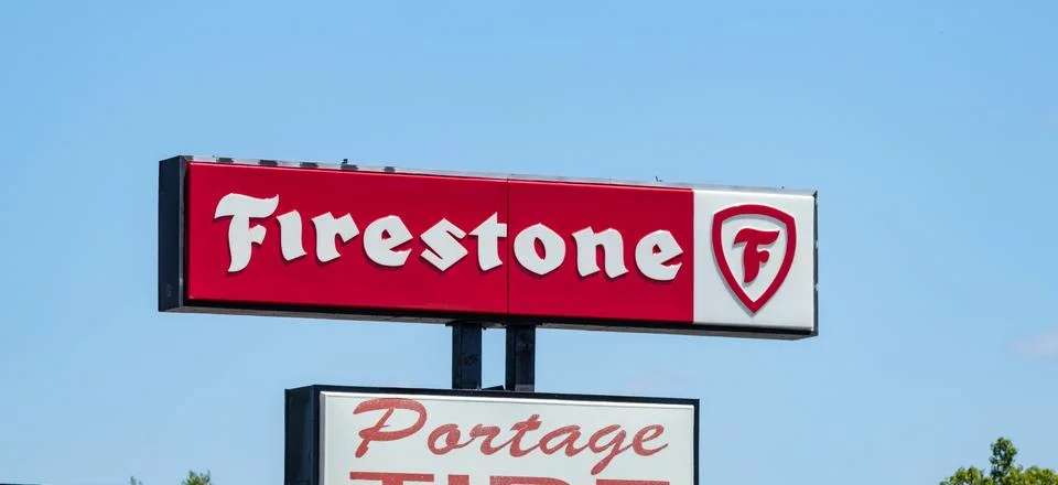 Firestone store sign against blue sky Stock Photos