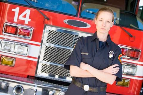 Firewoman standing in front of fire engine Stock Photos