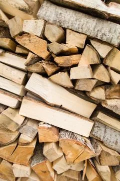 Firewood background - chopped firewood on a stack. Dry chopped firewood. Stock Photos