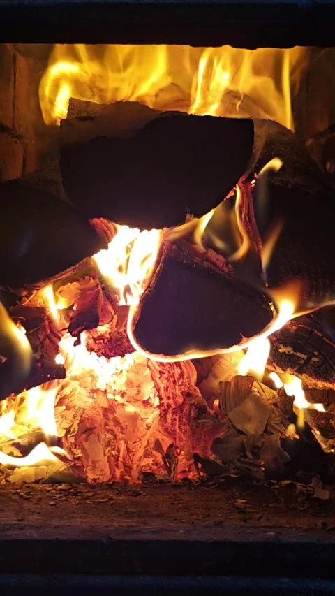 Firewood burning with bright yellow flames in a rustic fireplace Stock Footage 346134405