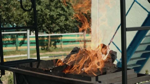 Firewood is burning in the grill, preparing coals for frying meat, open fire Video stock 205853344