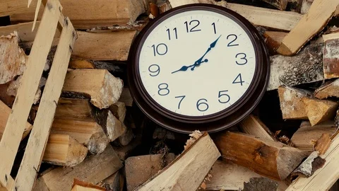 Firewood. The clock is on the wood. Time concept. The hour hand makes a full  Stock Footage 95118098