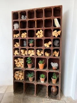 Firewood in a decorative stack with clay pots and plants Stock Photos