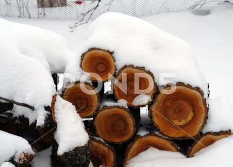 Firewood for the fireplace on the street under the January snow Stock Photos