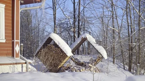 Firewood is stacked in the backyard. Firewood covered with snow Stock Footage 236549098