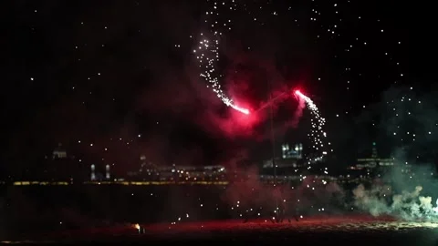 Firework burning outside on the beach - red fireworks spinning around and Stock Footage 133026258