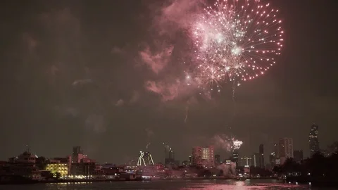 Firework exploding over buildings in city by river against sky at night - Stock Footage 129207633