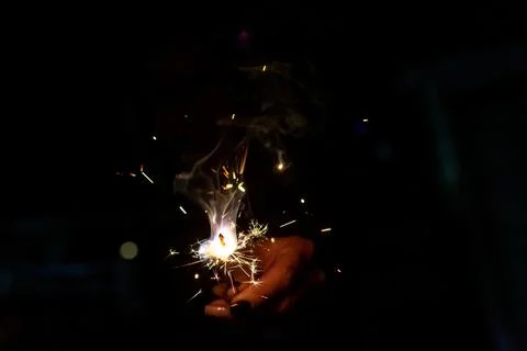 A firework held by one hand. Concept of celebrating Stock Photos