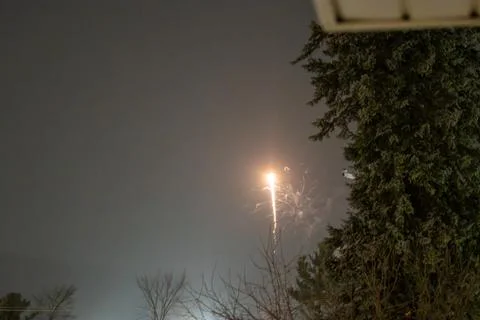 A firework shell launching into the night sky in winter Foto stock