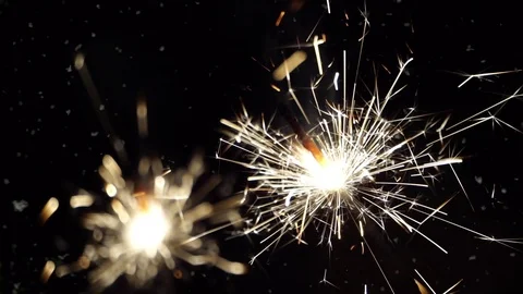 Firework sparkler burning with dancing snowflakes against night sky. Video stock 71336419