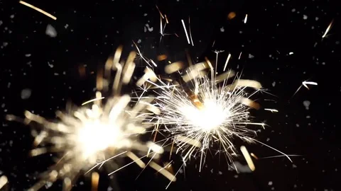 Firework sparkler burning with dancing snowflakes against night sky background. Video stock 71336806
