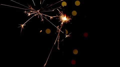 Firework sparkler burning with lights in background Stock Footage 143567170