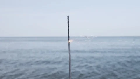 Firework sparkler burning with lights in sea background 動画素材 115030215