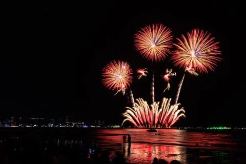 Fireworks And Spectator Silhouettes Exploding Over Ocean Beach In Pattaya T.. Fotos de archivo
