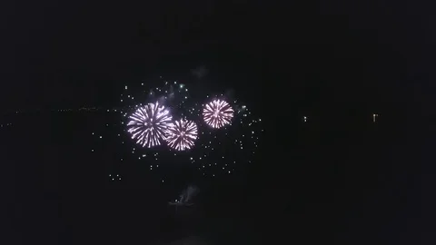 Fireworks are exploding inside black night sky, flying from base on river Stock Footage 102076492
