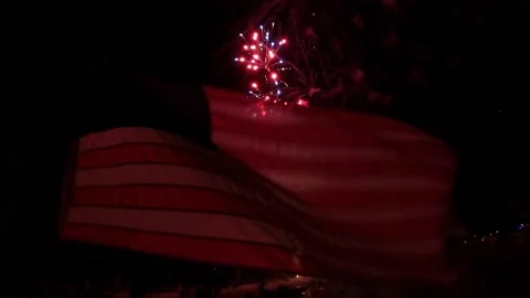 Fireworks behind American flag Stock Footage 157239970