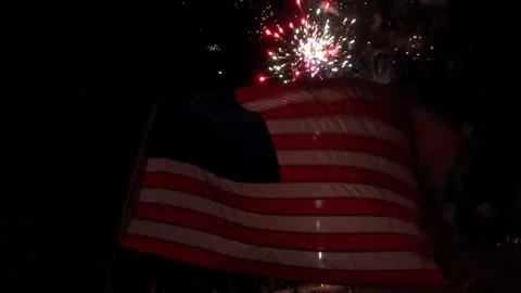 Fireworks behind flag Stock Footage 157240225