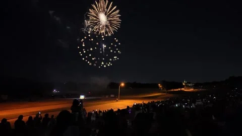 Fireworks display over airfield with spectators watching at night Stock Footage 340942051