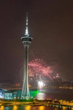 Fireworks explode above macau tower at night. Stock Photos