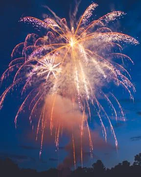 Fireworks explode over the sunset celebration Stock Photos