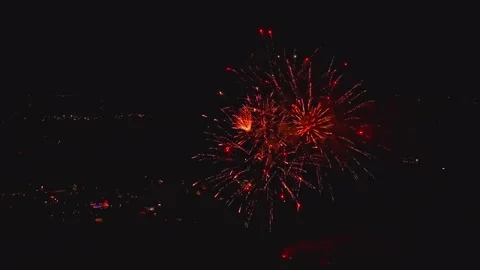 Fireworks explode in various colors over the city during a local festival at Stock Footage 345686442