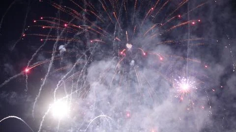 Fireworks exploding, creating colorful smoke trails in the night sky Stock Photos
