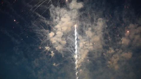Fireworks exploding creating smoke and light trails in the night sky Stock Photos