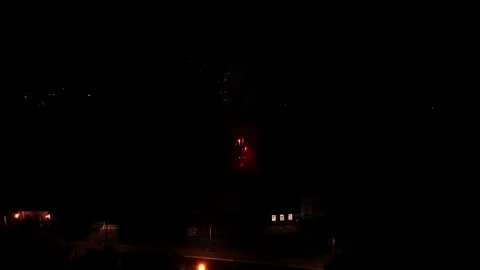 Fireworks exploding in the dark night sky over a city. Festive pyrotechnic Stock Footage 334534579