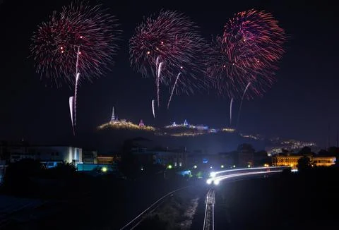 Fireworks Exploding Over Illuminated Hilltop Temple And Train Light Trails .. Stock Photos