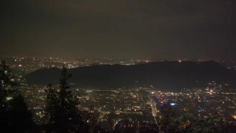 Fireworks exploding over night city New Years Eve wide pan 库存影片 336200983
