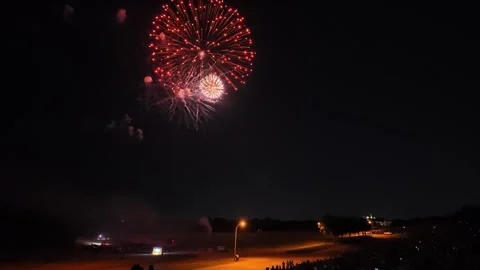Fireworks exploding over a park at night with spectators 動画素材 340942143