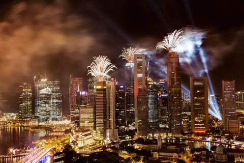 Fireworks exploding over skyscrapers at illuminated cityscape 库存照片