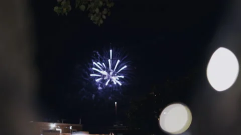 Fireworks exploding over small town on 4th of July with lights in Stock Footage 168812402
