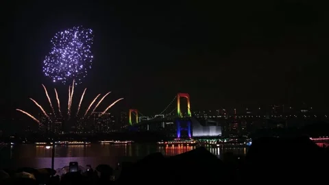 Fireworks exploding over Tokyo's Rainbow Bridge at night 動画素材 329112122